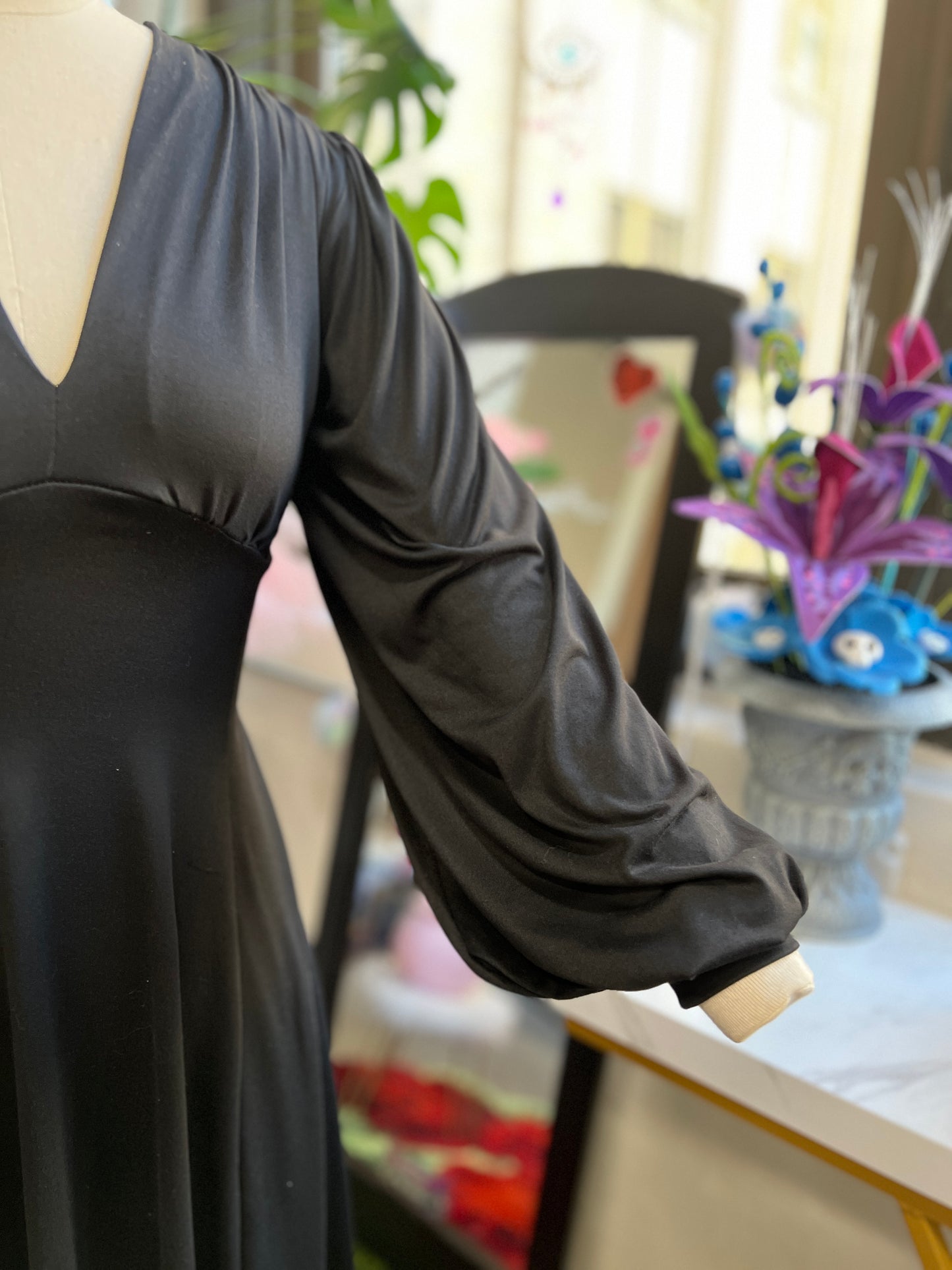 Close-up of Raquel Maxi Dress in Jet Black, showcasing stretchy bishop sleeves in soft black brushed knit.