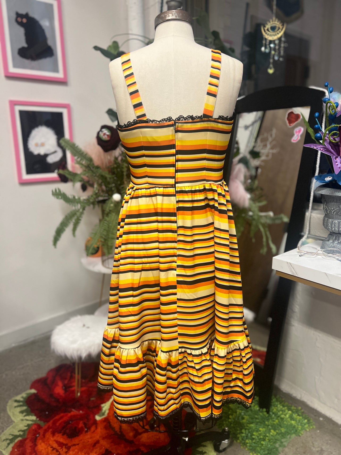 Back view of Heidi swing dress in candy corn stripe with lace trim and ruffles, featuring pockets and a lace-up front.