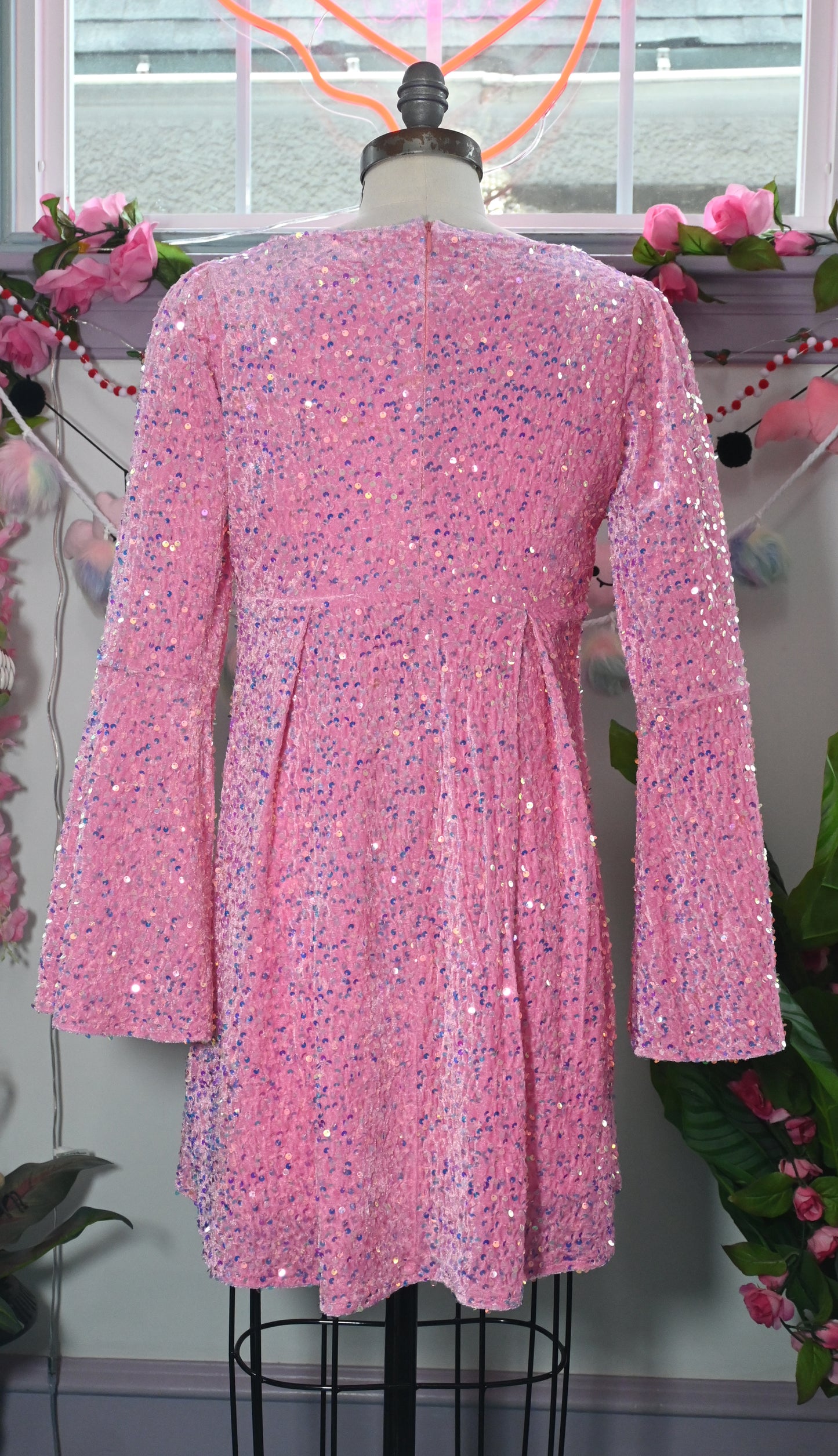 Back view of a cute pink sequin velvet mini dress with 60s bell sleeves and full lining, perfect for fun occasions.