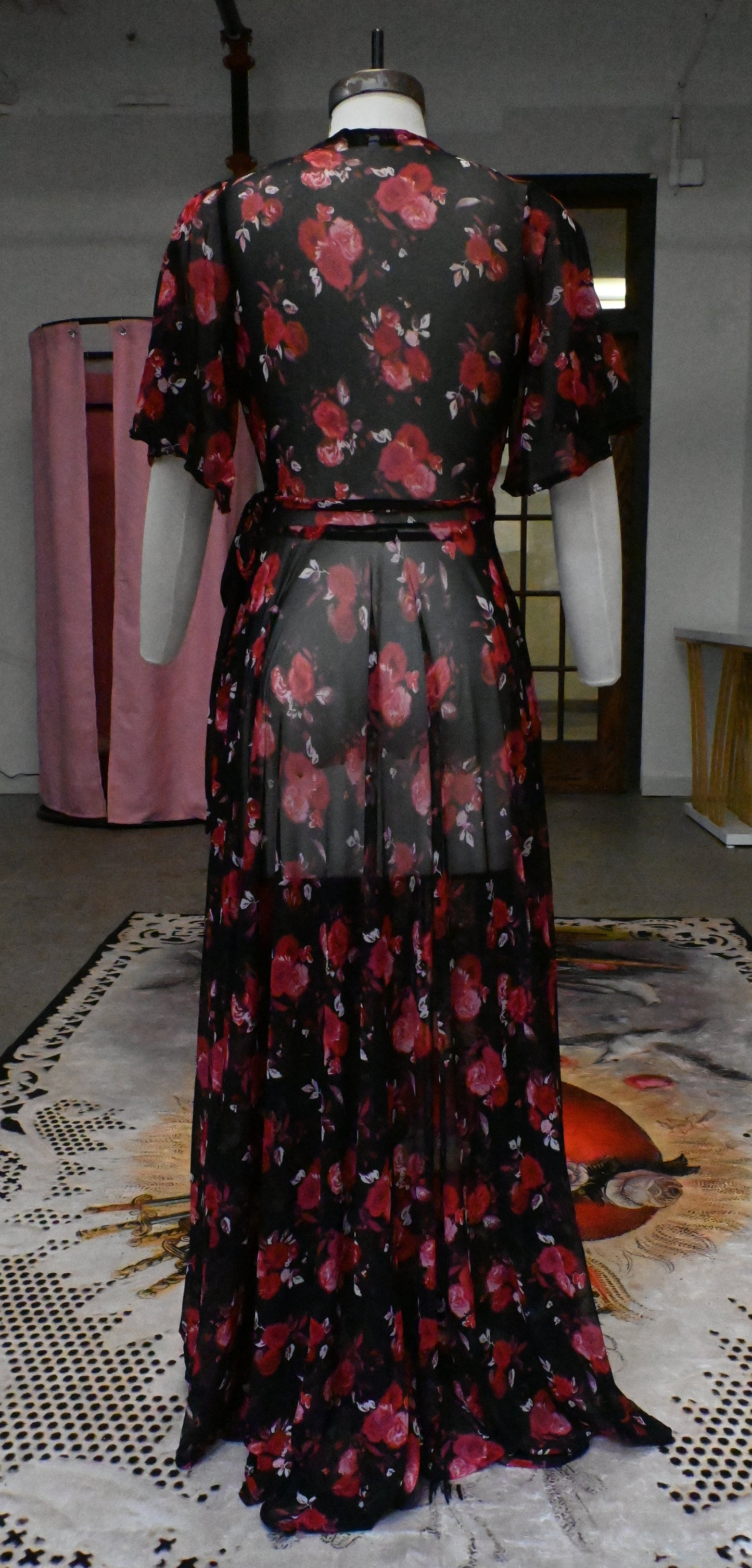Back view of soft mesh maxi wrap dress in rose cluster print, featuring dramatic sleeves and convenient pockets.