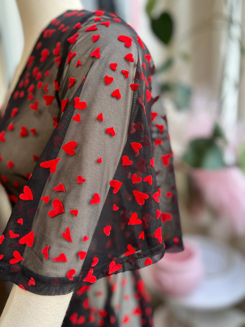 Black mesh wrap maxi dress with red hearts, perfect for Valentine's Day and featuring stylish pockets.