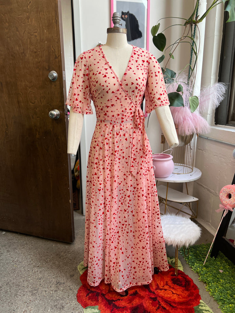 Pink mesh maxi wrap dress with red flocked hearts and pockets, perfect for Valentine's Day.