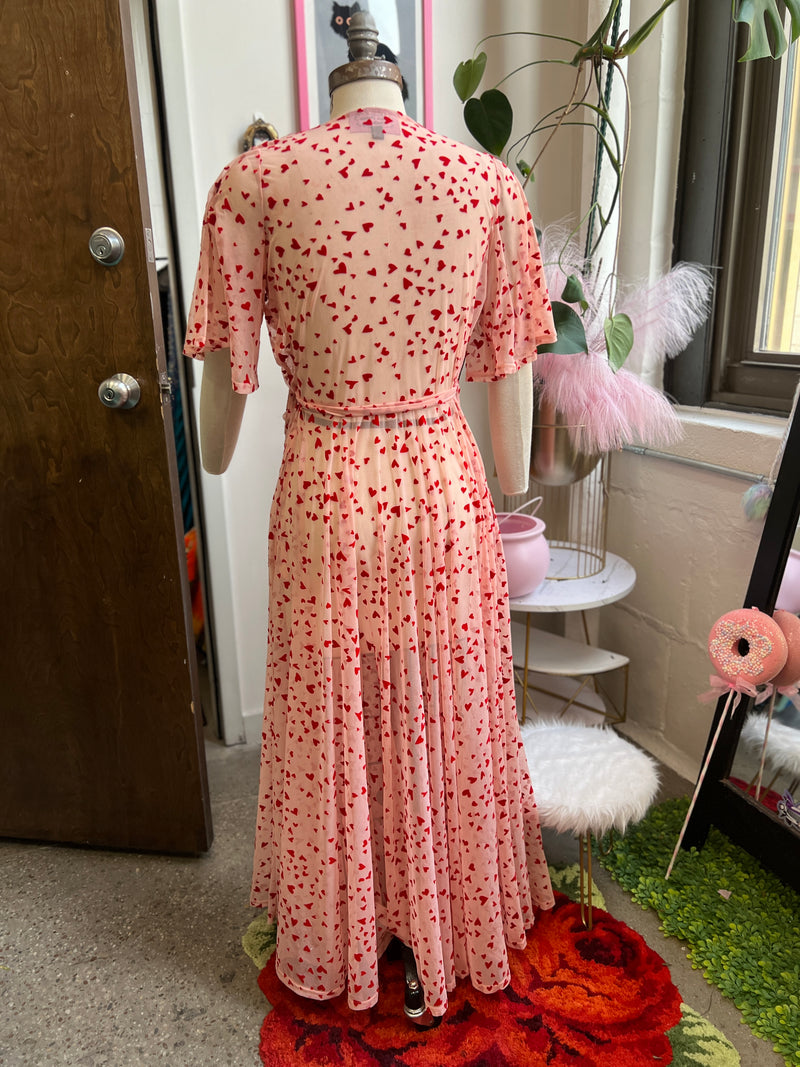 Back view of Lydia pink mesh maxi wrap dress with red flocked hearts and pockets, perfect for Valentine's Day.