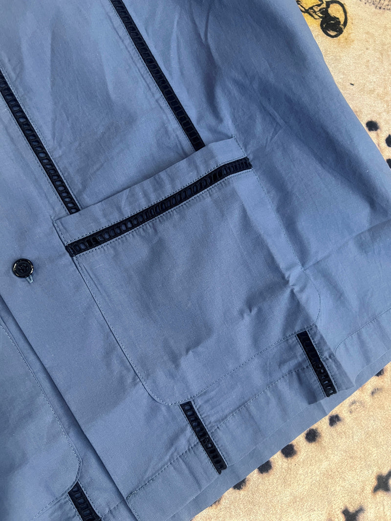 Close-up of Men's Working Blues Cocktail shirt with pockets, black trim, and buttons, made from 100% cotton.