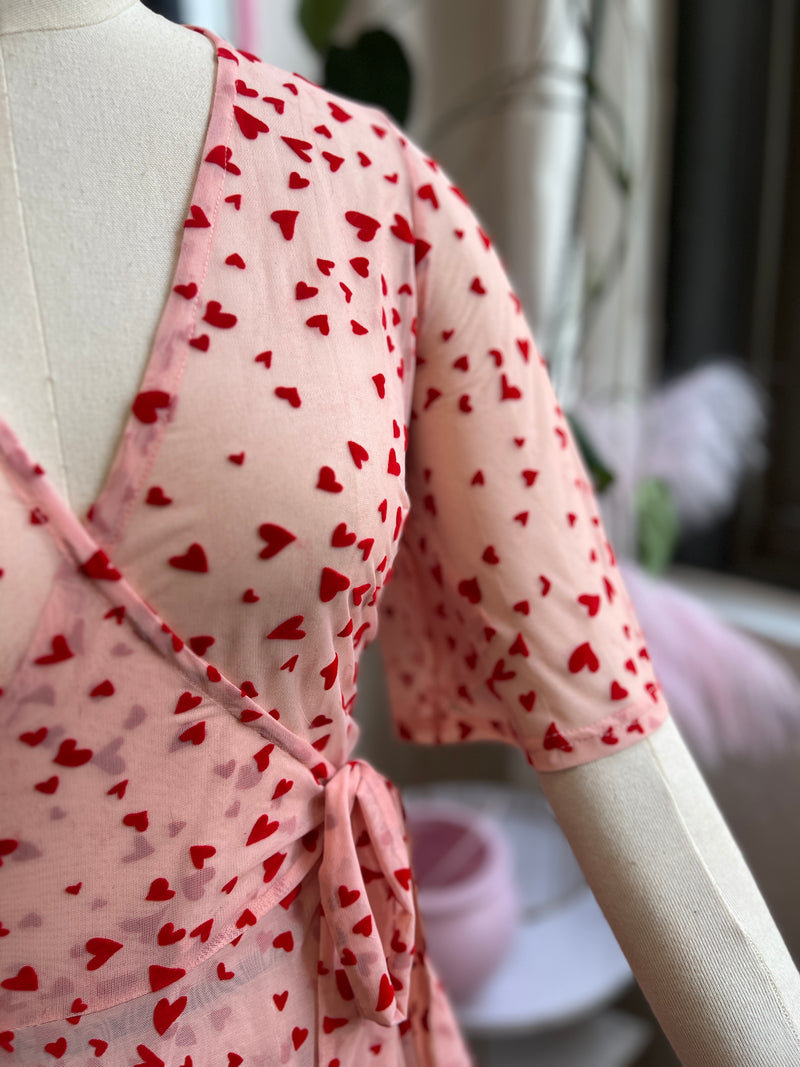 Pink mesh maxi wrap dress with red flocked hearts and pockets, perfect for Valentine's Day.