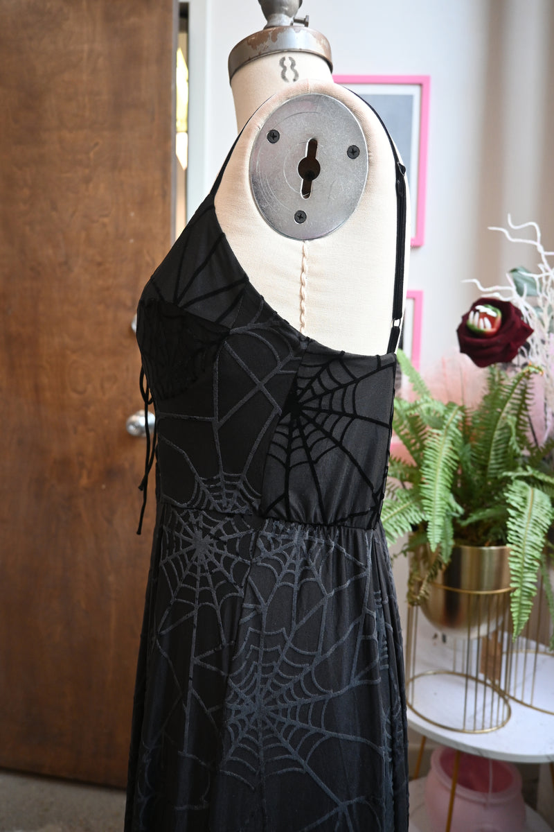 Side view of the black Willow Dress featuring spiderweb burnout, adjustable velvet straps, and flowing asymmetrical hem.