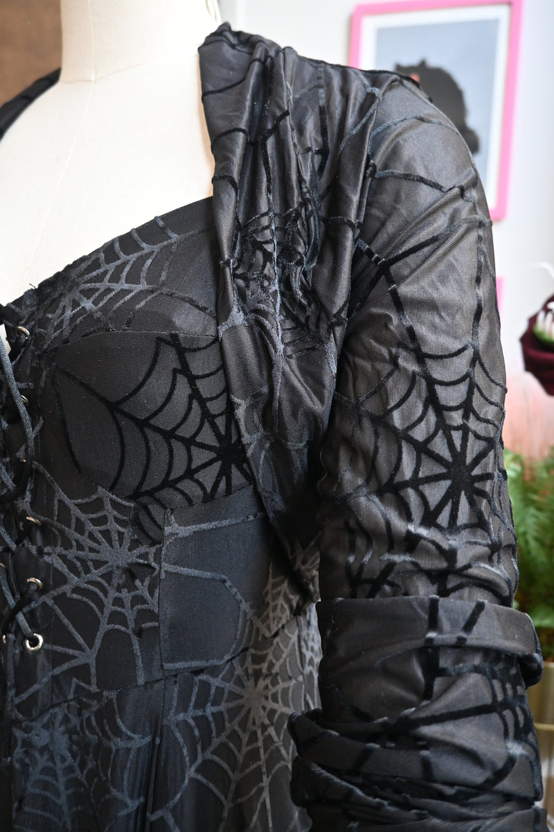 Close-up of the goth-inspired black spiderweb burnout velvet dress featuring adjustable straps and lace-up front.