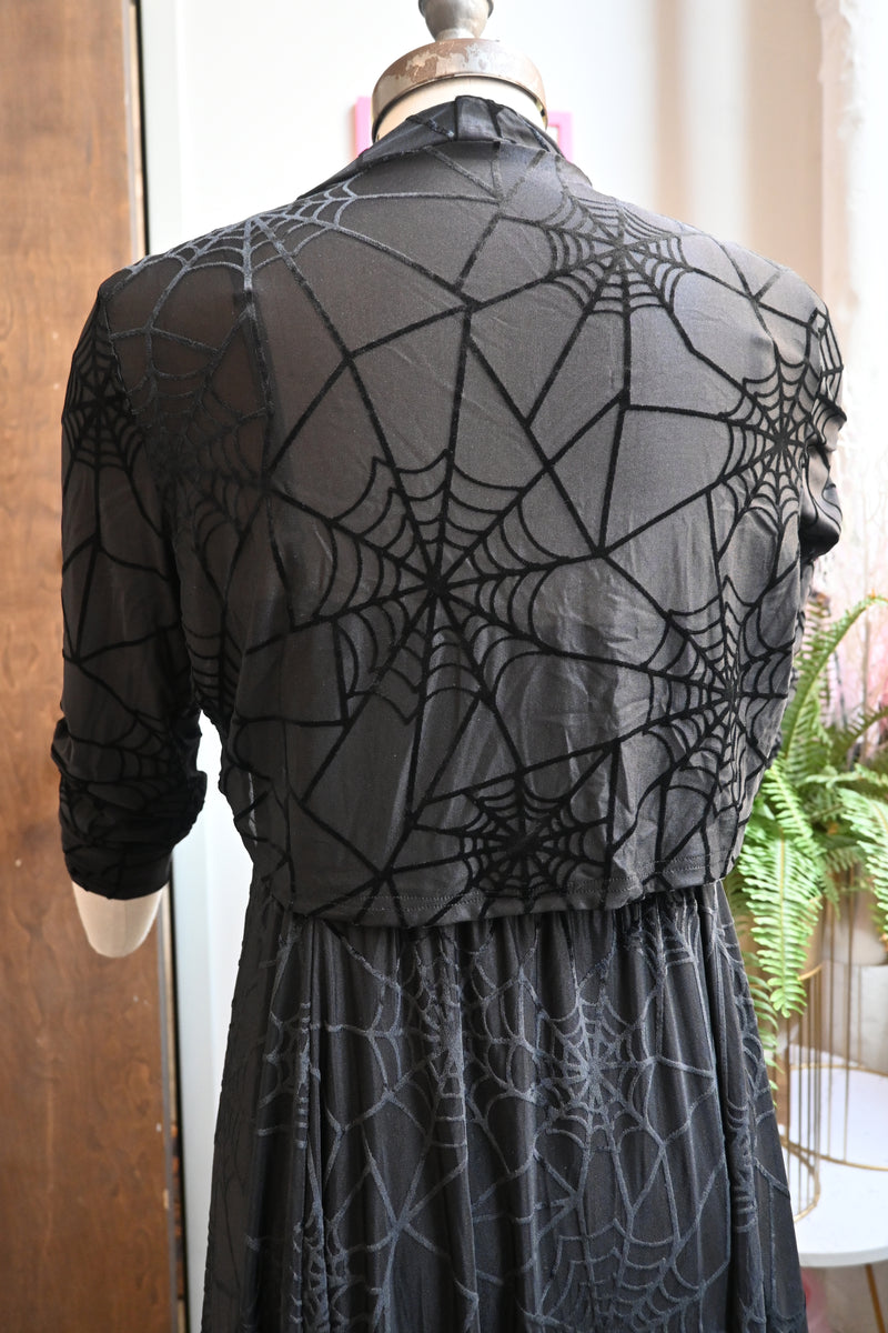 Back view of Black Willow Dress with spiderweb burnout design, featuring an asymmetrical hem and velvet straps.