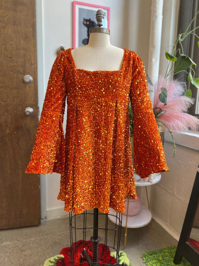 60's inspired pumpkin orange sequin velvet dress with bell sleeves and removable bow, perfect for Halloween.