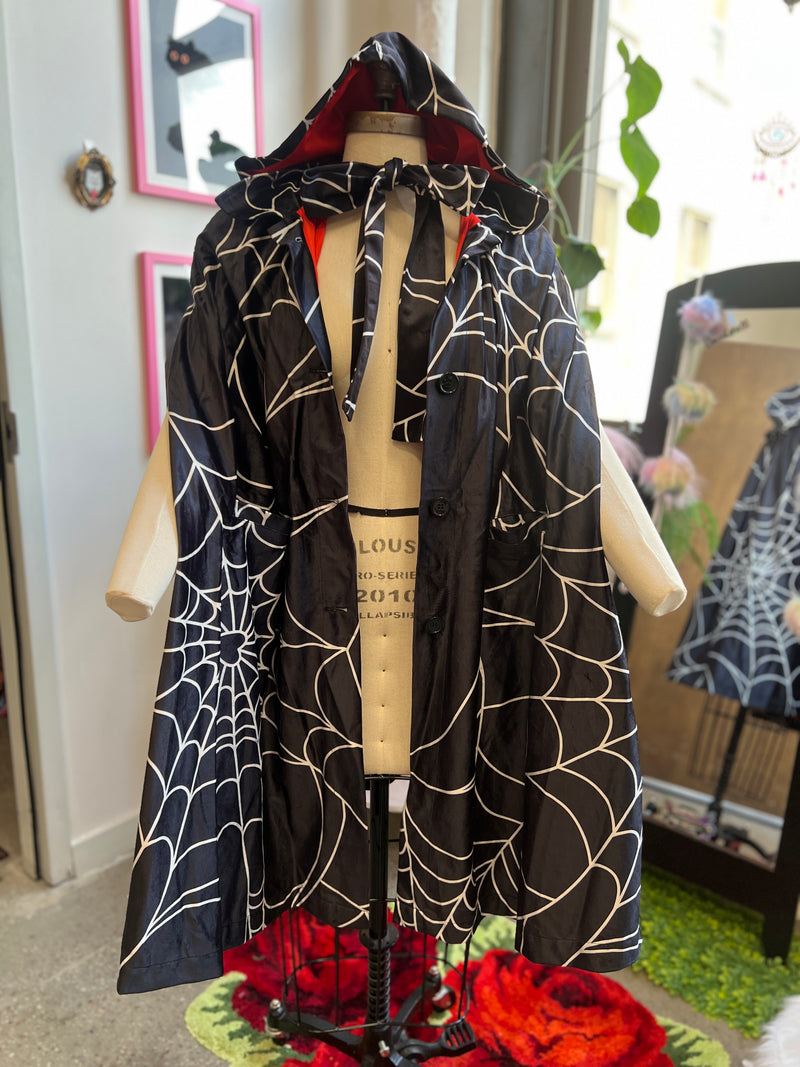 Florence Hooded Cape in Spiderweb Print with red satin lining and deep pockets, inspired by antique nurses' cloaks.