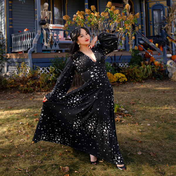 Raquel Maxi Dress with Bishop Sleeves in star cluster print, showcasing a glamorous, comfortable fit in a spooky outdoor setting.